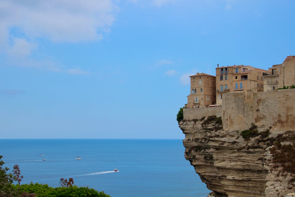 Bonifacio con case bianche sulle falesie e barche sottostanti