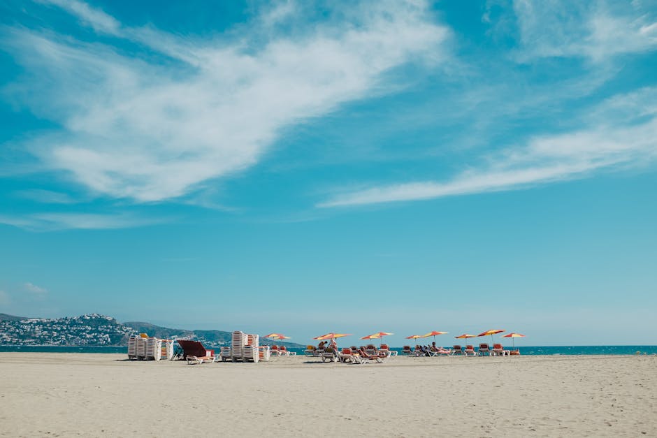 Zandstrand van Calvi met ligstoelen en turquoise zee