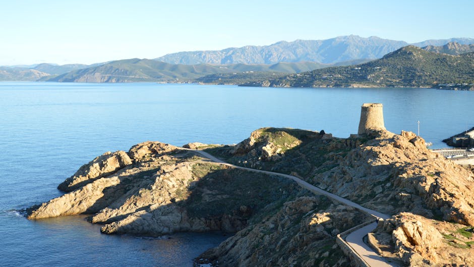 strada costiera del Cap Corse con torre in pietra e mare blu