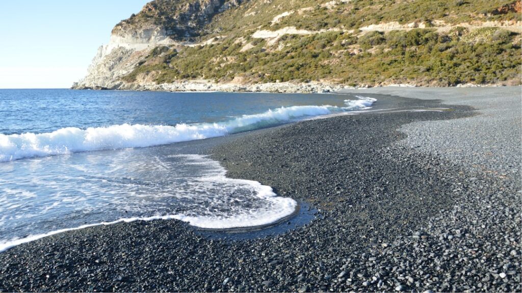 Nonza an der Klippe mit schwarzem Kiesstrand und dramatischer Küstenansicht
