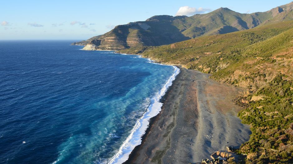 spiaggia di ciottoli neri di Nonza e torre sulla scogliera