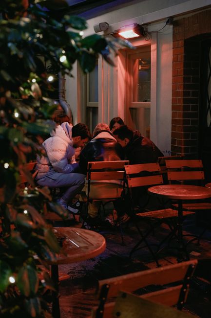 Freundesgruppe trifft sich in einem Außen-Café bei Nacht