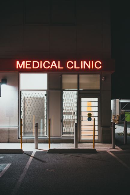 Eingang einer medizinischen Klinik mit Notfallschild bei Nacht