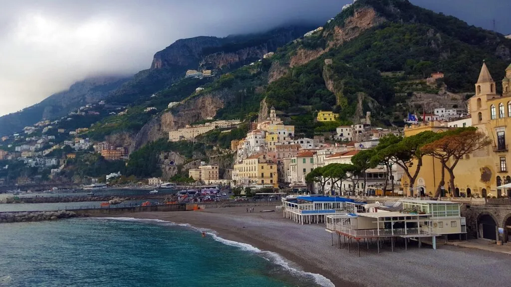 Amalfi coastline with pebble beach and hillside pastel buildings