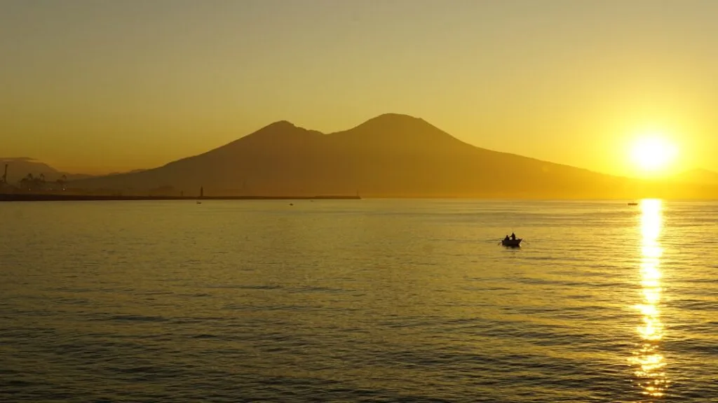 Vesuv im Sonnenuntergang über der Bucht vor Neapel mit Boot.