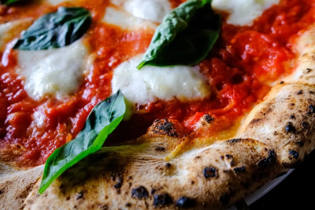 Close-up of Neapolitan margherita pizza with basil and charred crust in Naples