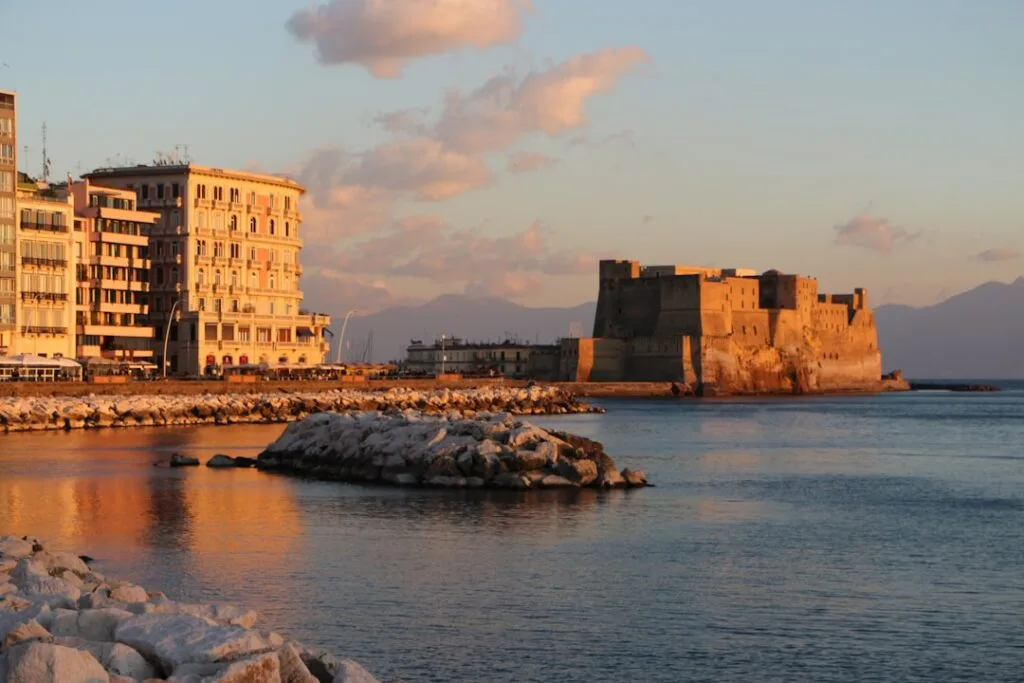 Castel dell'Ovo and seafront buildings bathed in golden sunset light