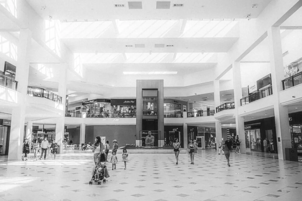 Spacious mall atrium with families, stroller and shops in Naples