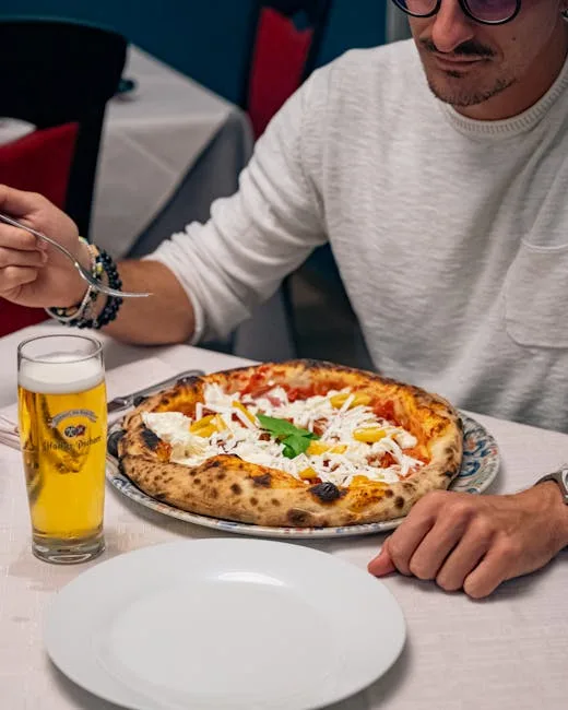 Diner at Naples table about to eat pizza with beer