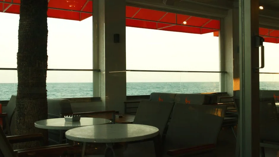 Empty seaside café interior with red awning and sea view in Naples
