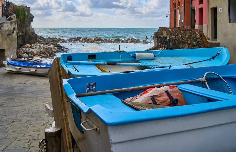 Blue fishing boats lined on Naples waterfront with rocky coast and sea