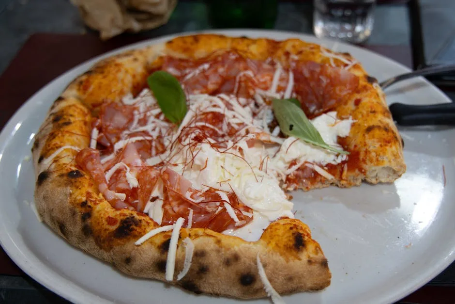 Close-up of sliced Neapolitan pizza with prosciutto and basil