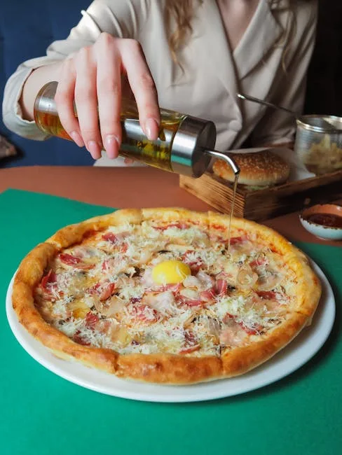 Pouring olive oil over pizza