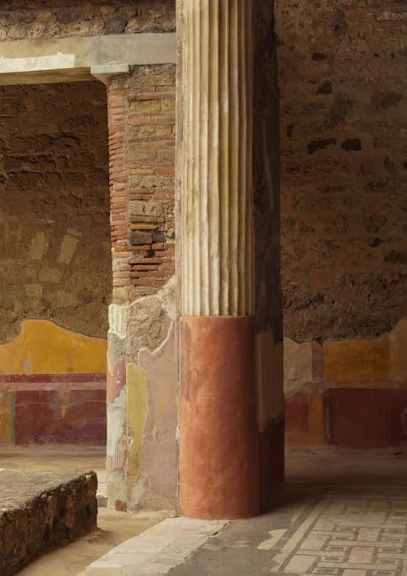 Fluted column amid painted plaster walls and mosaic floor in Pompeii