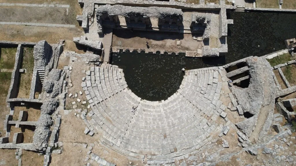 Aerial view of semicircular Roman theatre seating at Naples ruins