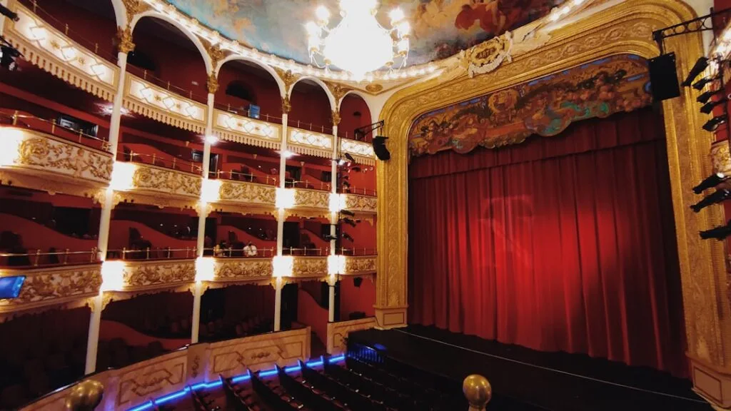Ornate red-curtained theatre interior with gilded balconies in Naples
