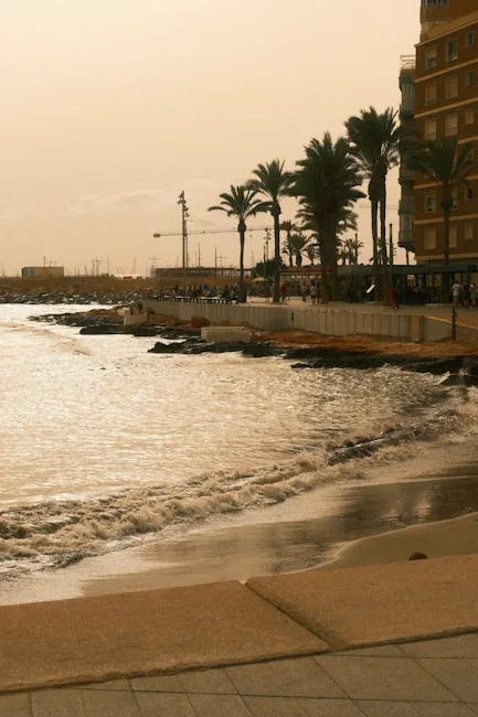 Palm-lined Naples seafront promenade with waves lapping at the shore