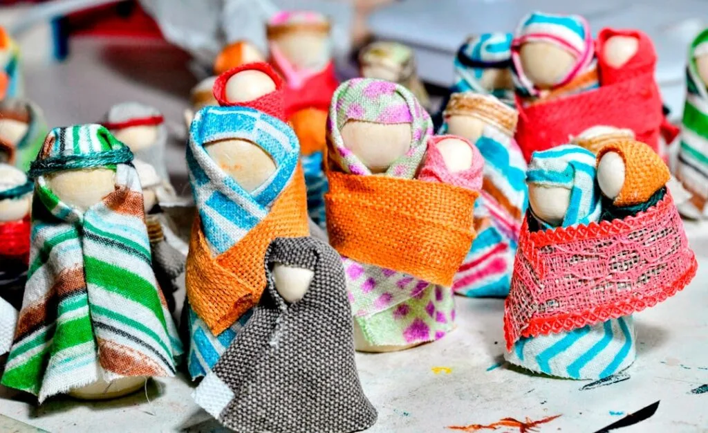 Colorful handmade fabric dolls displayed for sale at a Naples market