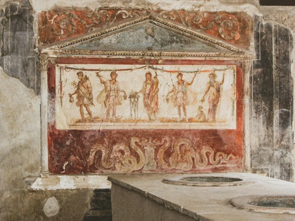 Colorful ancient fresco above stone counter inside Pompeii archaeological house