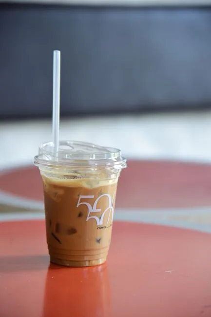 Eiskaffee im Plastikbecher auf rotem Tisch in Neapel