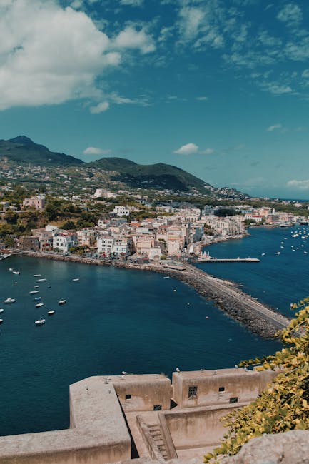 Luftaufnahme der Ischia-Küste mit Hafen, Uferpromenade und Bergen im Hintergrund