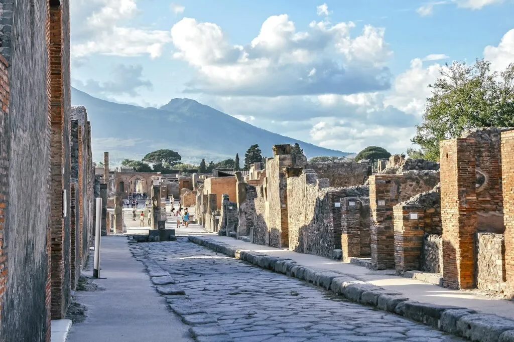 Antike Straßenruinen in Pompeji mit dem Vesuv im Hintergrund, bei Neapel.