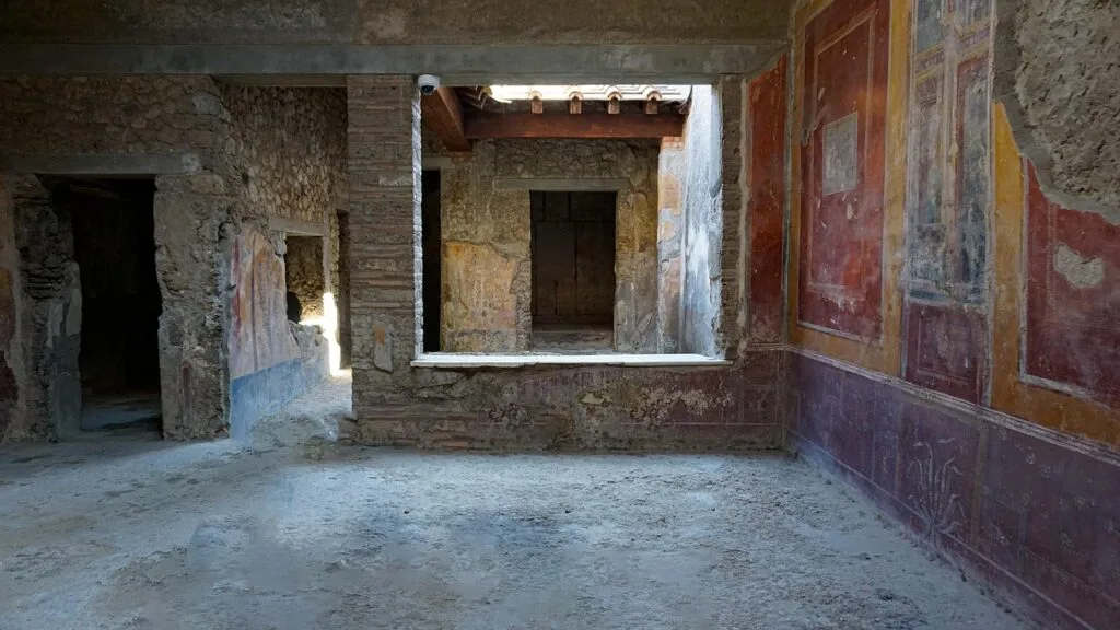 Verlassener römischer Raum mit farbigen Wandfresken in Pompeji.