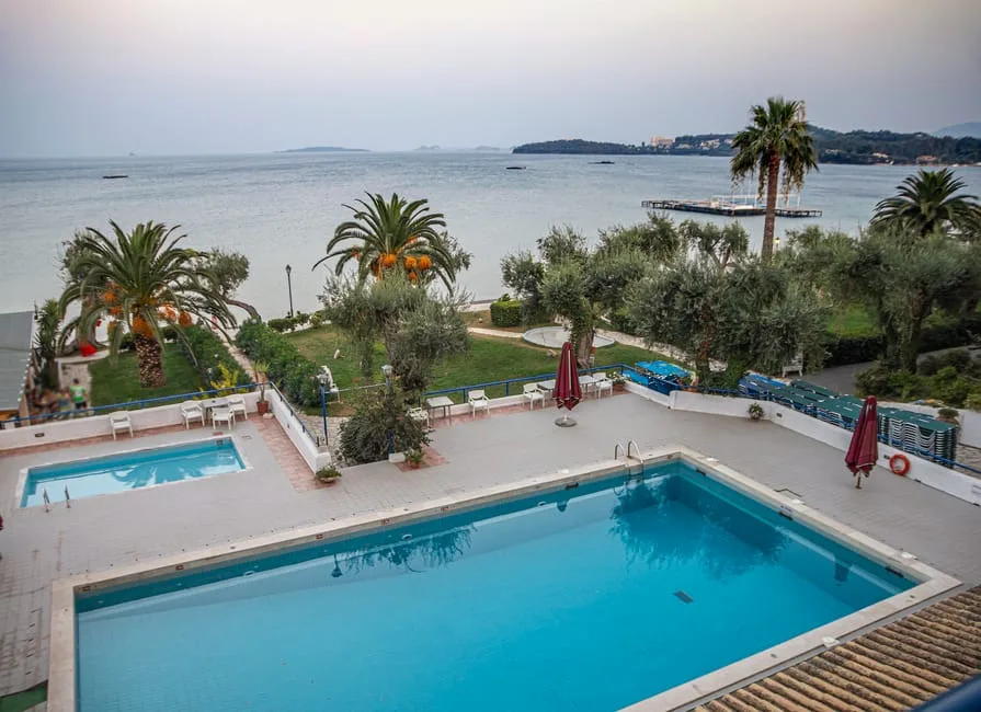 Blick auf Hotelpool, Palmen und ruhiges Meer an der Küste von Ischia