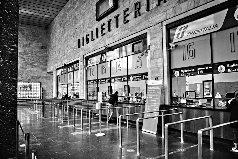 Schwarzweißes Bahnhofs-Biglietteria mit Ticketschaltern und Warteschlangen in Neapel