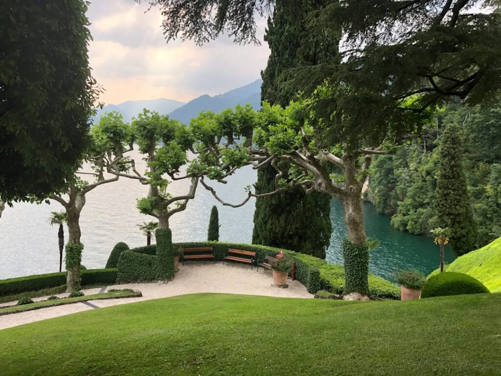 Garten-Terrasse mit geschnittenen Platanen und Bänken mit Blick auf den Comer See