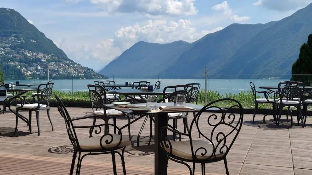 Terrasse de café avec chaises métalliques face au Lac de Côme