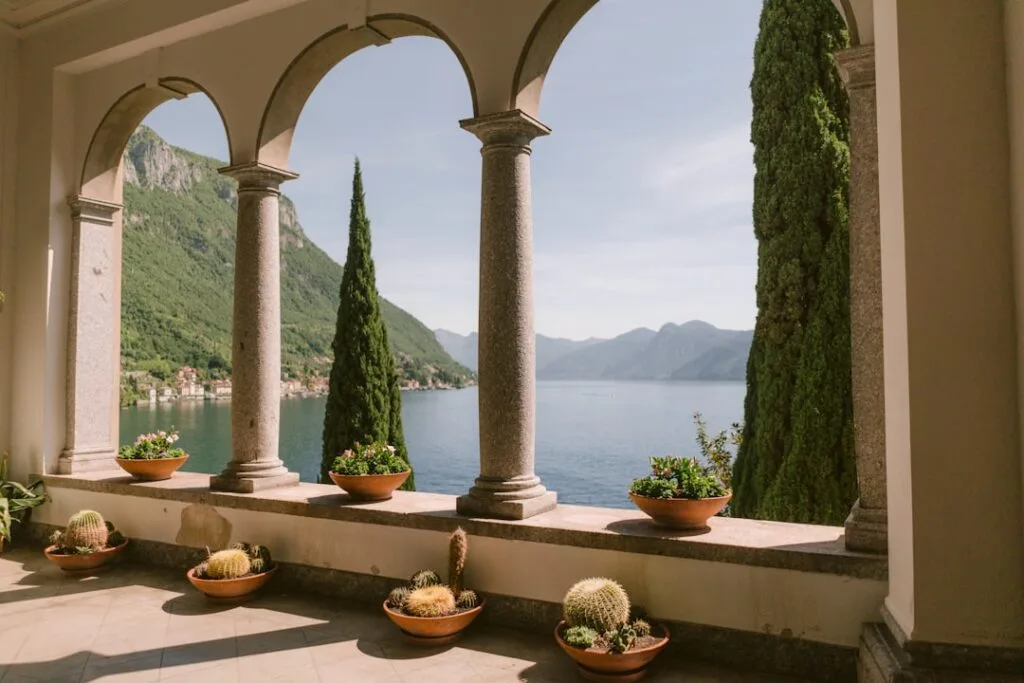 Loggia à arcades avec pots de cactus offrant vue sur le lac de Côme