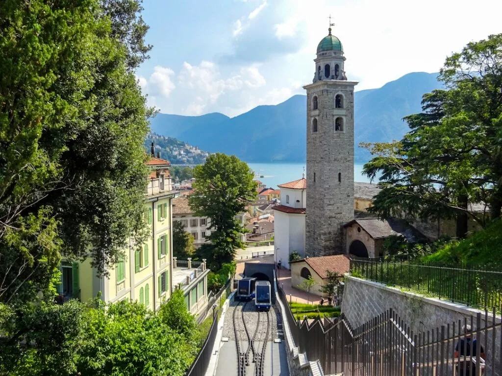 Bergbahntrasse hinab zur Stadt mit Glockenturm und Comer See