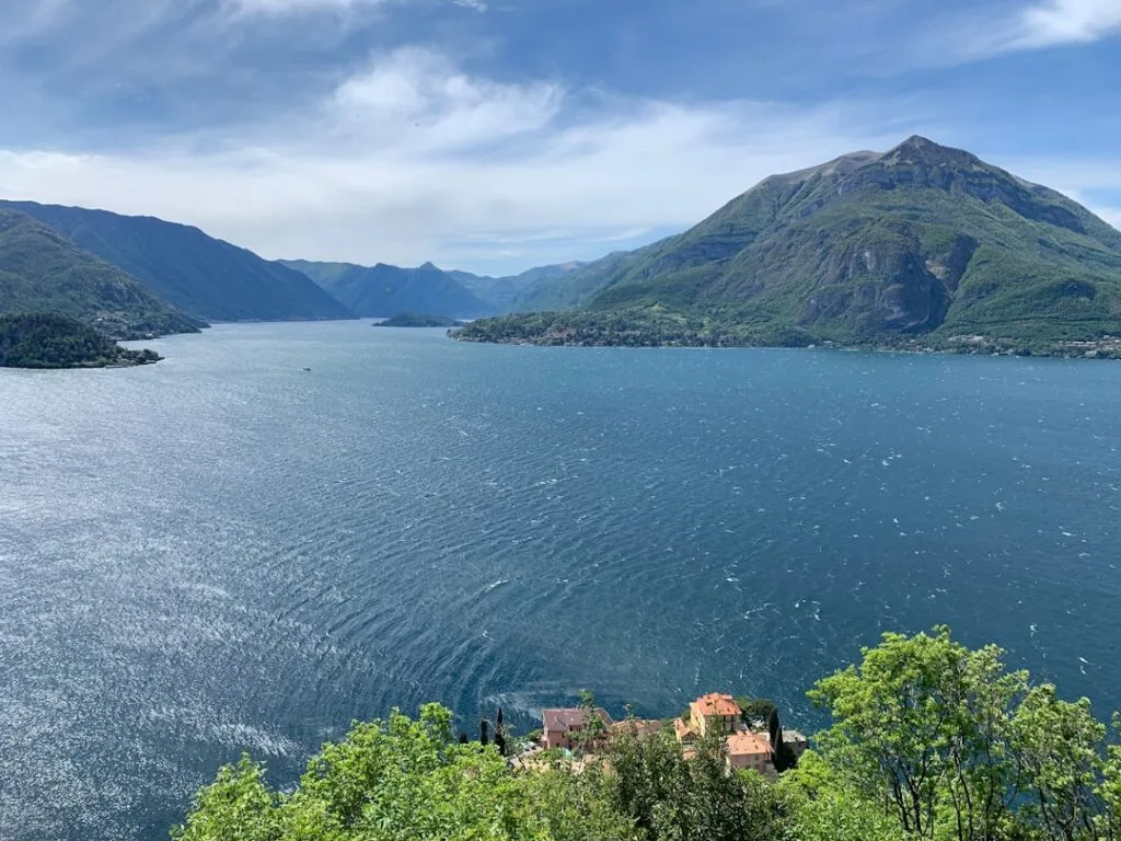 Panoramablick auf den Comer See mit grünen Bergen und kleinen Halbinseln.