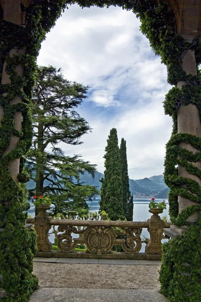 Balcon en pierre encadré de colonnes végétales, vue sur Lac come