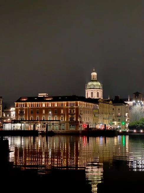 Façades illuminées et dôme se reflétant sur les eaux du Lac de Côme