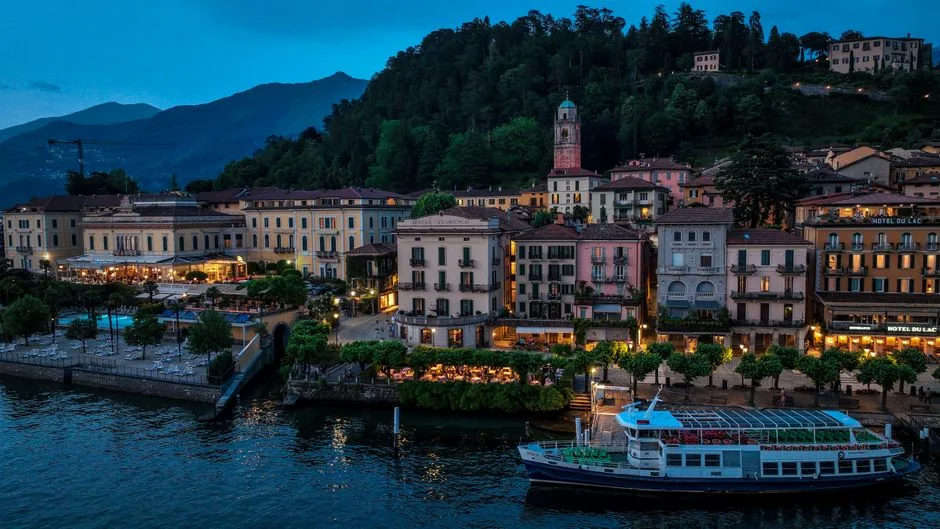 Vue nocturne des façades et bateaux sur le rivage du Lac de Côme