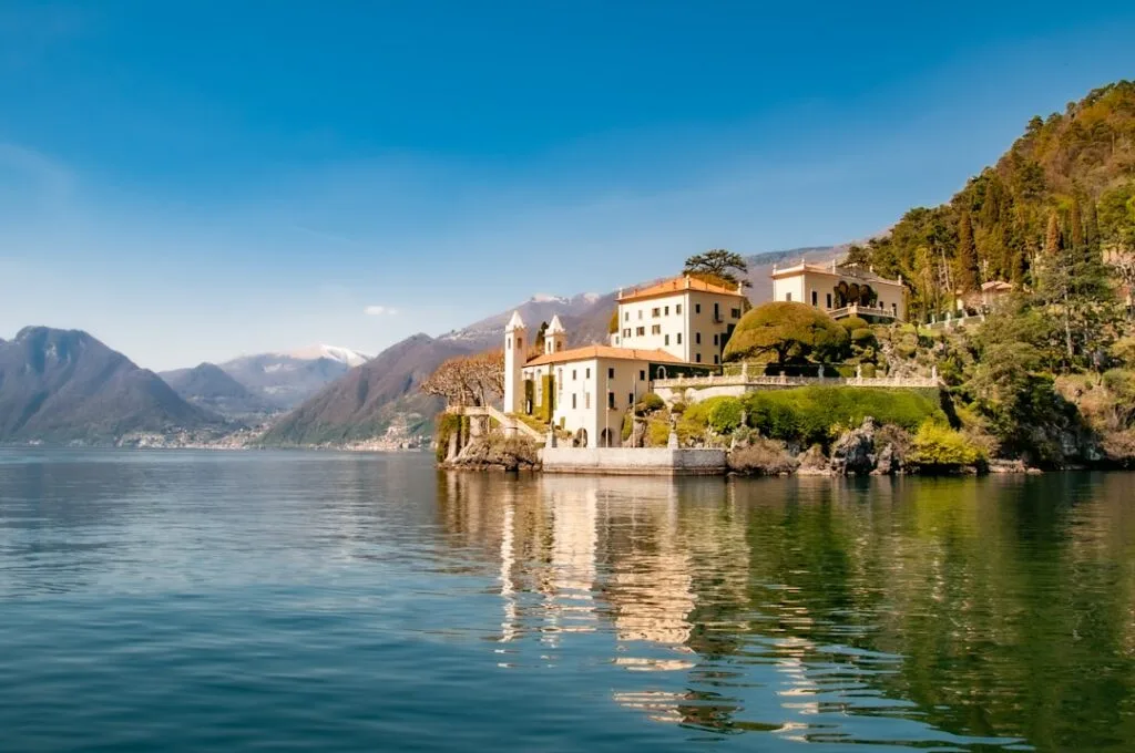 Villa jaune sur la rive du Lac de Côme, montagnes en arrière-plan