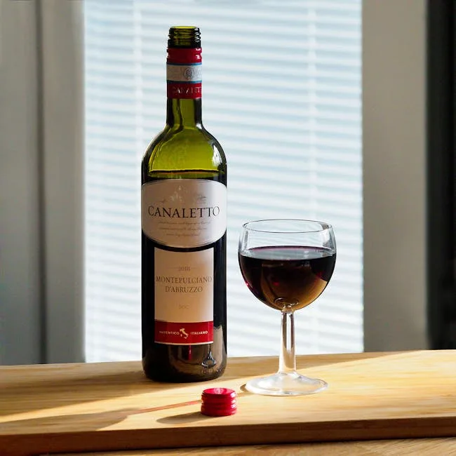 Bouteille de vin rouge toscan et verre posé sur planche en bois.