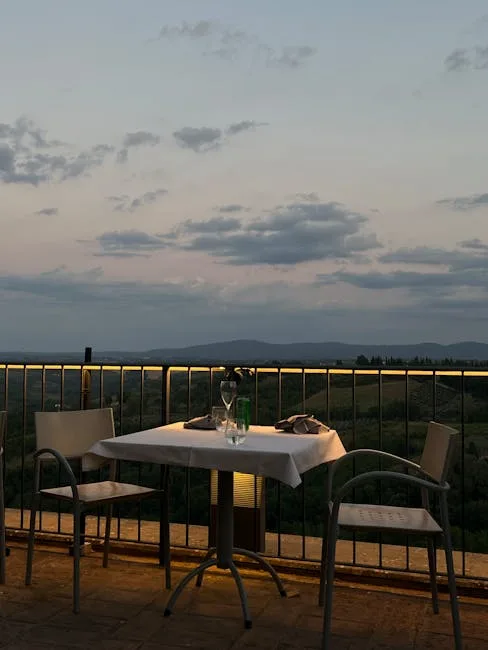 Terrasse avec table dressée et vue sur la campagne de San Gimignano