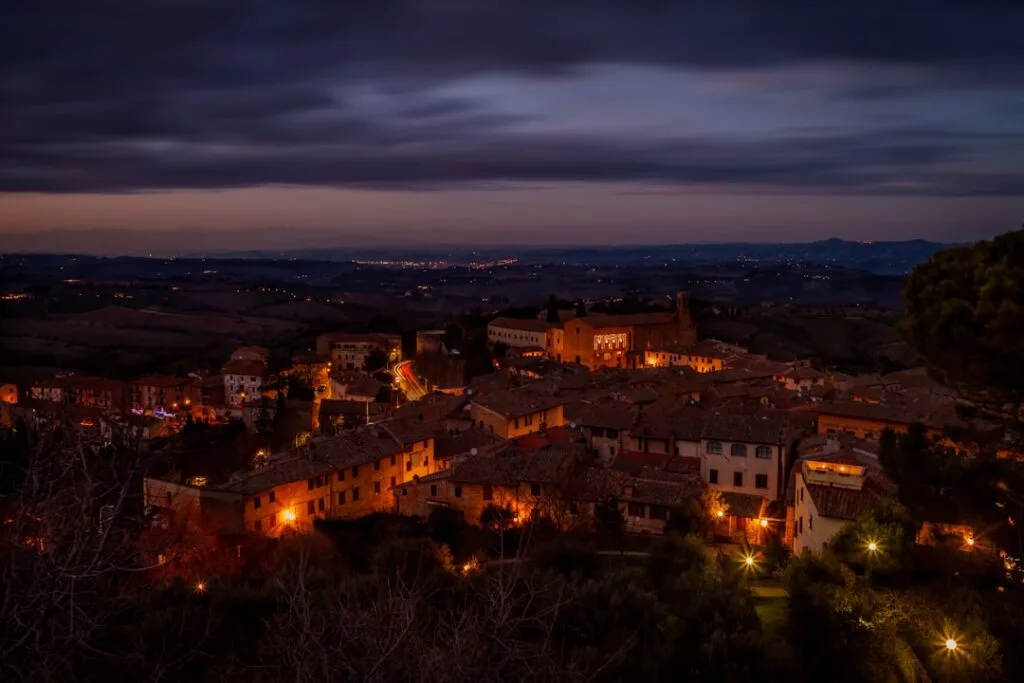 Vue nocturne panoramique de San Gimignano et collines toscanes