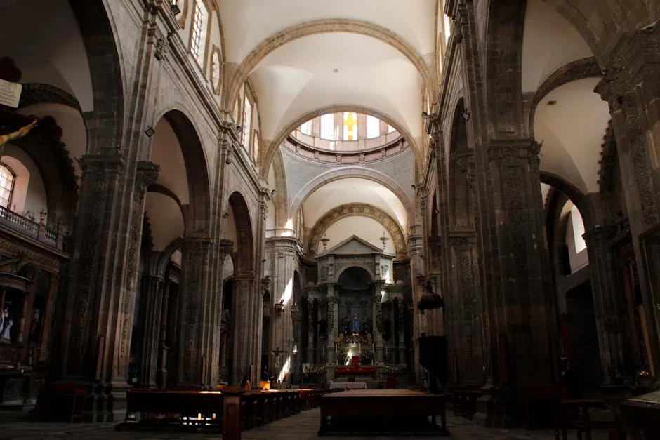 Nef voûtée d'une église de San Gimignano avec autel central.