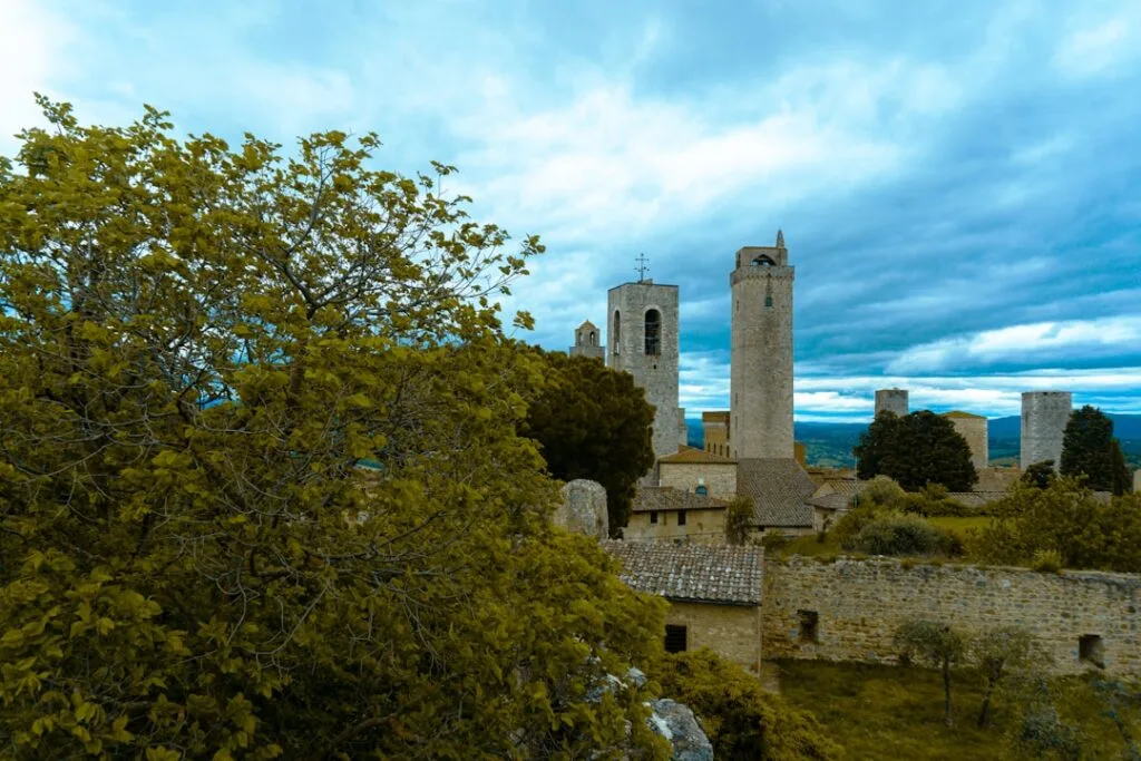 Tours médiévales de San Gimignano émergeant derrière des arbres verts