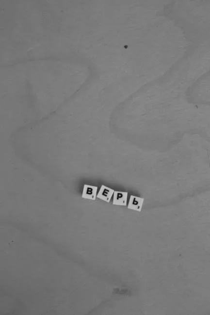Surface en bois gris avec quatre lettres Scrabble alignées au centre