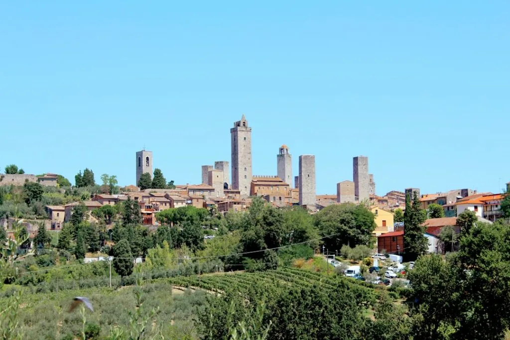 Panorama des tours médiévales de San Gimignano sur collines verdoyantes.