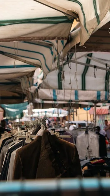 Kledingstallen onder gestreepte kramen op de centrale markt van San Gimignano