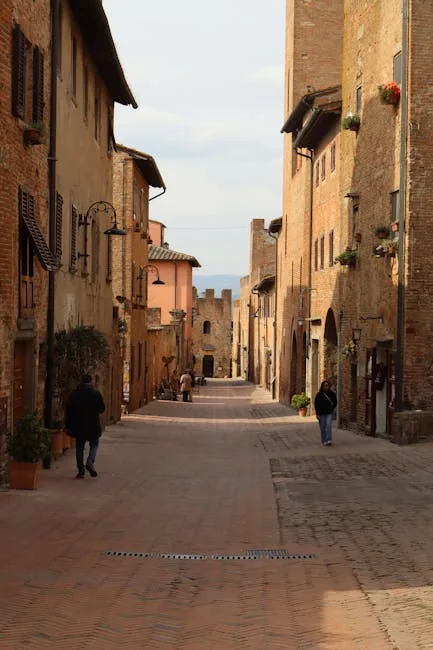 Rue pavée bordée de bâtisses médiévales dans la vieille ville de San Gimignano