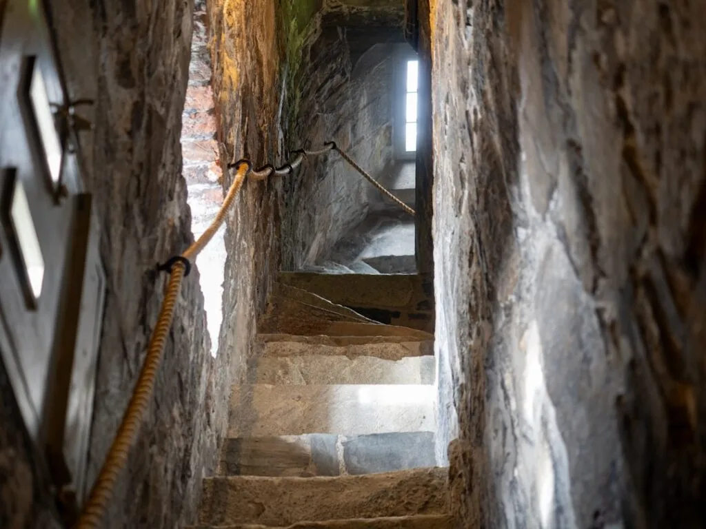 Escalier étroit en pierre avec corde d'appui dans une tour de San Gimignano