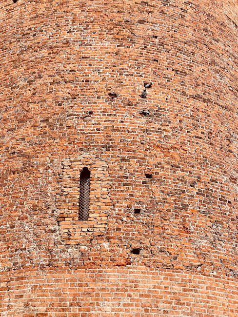 Close-up of stonework on a medieval tower showing arrow slits and masonry