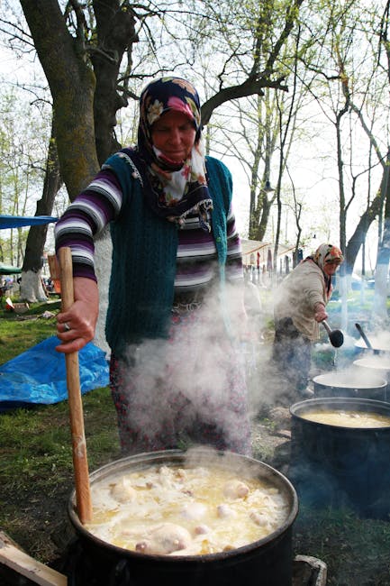 Outdoor village food festival with tents cooking tripe stew